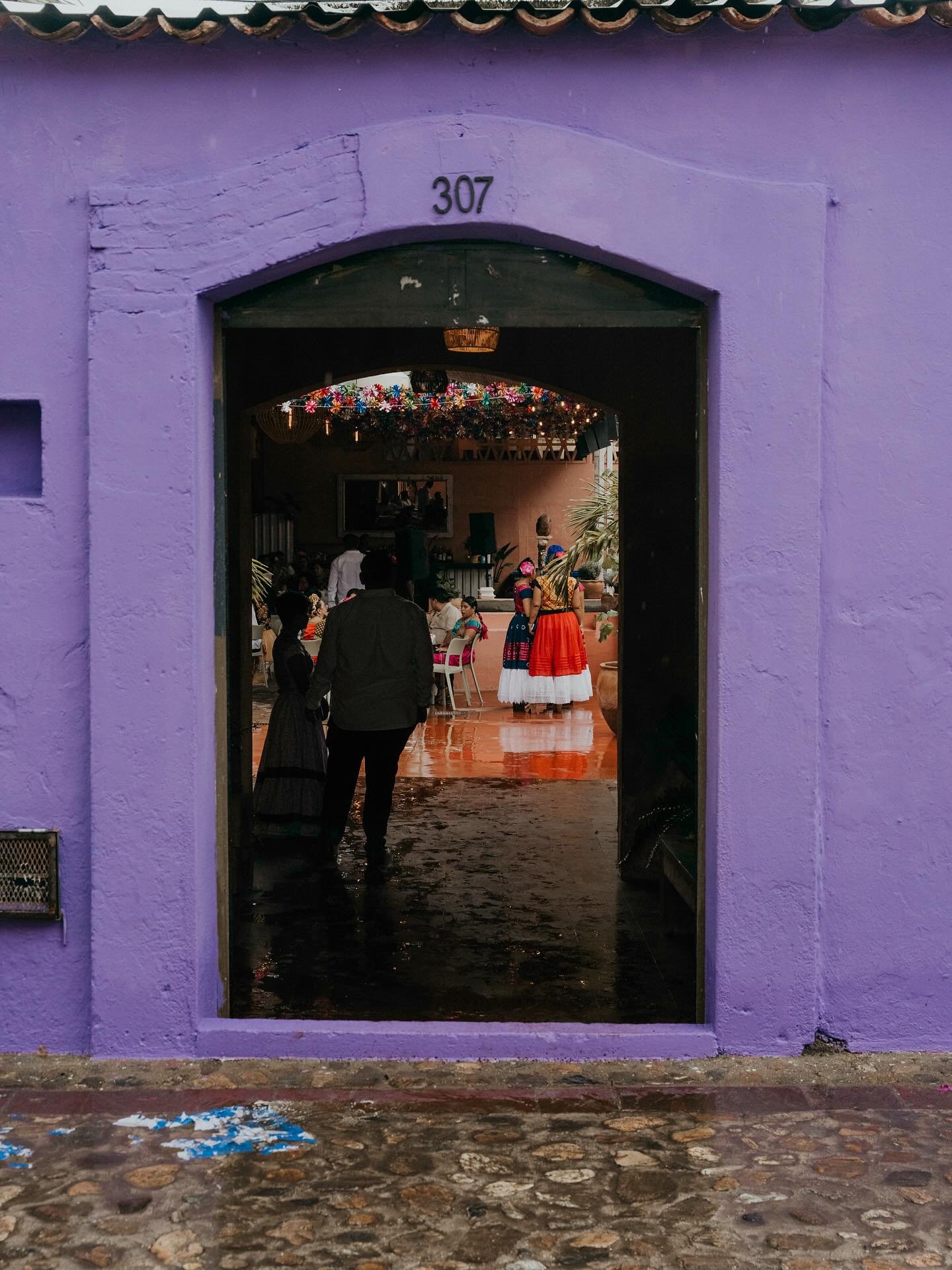 Entrada del restaurante, con fachada púrpura y el número 307, abierta hacia el patio interior.